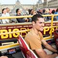 Hombre a bordo de un autobús de Big Bus Tours en París afuera del Louvre